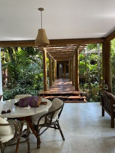 a table and chairs in a room with plants on either side of the door way