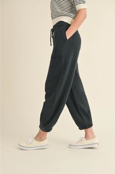 Women's Loose Pleated Joggers Drawstring Knit Lounge Pants Introducing our latest arrival: Drawstring Knit Lounge Pants! Available in two trendy colors, these pants boast a drawstring, convenient side pockets, pleated accents, and a cozy jogger style. Made with soft ribbed fabric, you'll never want to take them off. With a cute, cozy, and chic aesthetic, these pants feature a loose fit for maximum comfort. Complete the look by pairing them with our matching shirt (sold separately). Trust us, you Casual Drawstring Pants For Fall, Relaxed Fit Bottoms With Drawstring For Fall, Fall Leisure Pants With Drawstring, Everyday Solid Color Pants With Drawstring, Everyday Drawstring Pants, Winter Loungewear Bottoms With Drawstring, Drawstring Pants For Winter Lounging, Comfortable Drawstring Winter Pants, Leisure Drawstring Bottoms For Fall