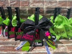 several black and green bows are tied to the side of bottles with writing on them