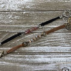 two necklaces with beads and charms on wooden background