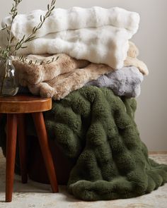 a pile of blankets sitting on top of a wooden table