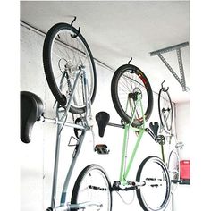 there are two bikes hanging on the wall and one is upside down with wheels attached to it