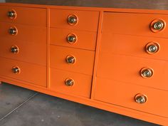 an orange dresser with brass knobs on the top and bottom drawers is shown in this image