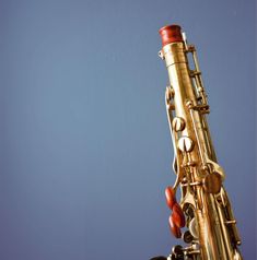 a close up of a saxophone against a blue background