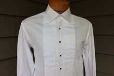 "-Unknown maker- R. Charles, LTD. (Alpharetta, Georgia) all cotton Medium - Large, nor labeled for size (please rely on measurements provided) 1990's or newer Unknown maker formal shirt with retailer label. A custom / made-to-order shirt, possibly Individualized Shirt Co. of New Jersey. Pure White, patterned weave cotton with fine vertical ribs. A very well made shirt. Pearl buttons which are hand applied. I recently ordered some dress shirts from Individualized thru a local clothier...Starting range in the bottom tier fabrics is $250...It only goes up from there. Please note: This shirt requires four (4) shirt studs and a pair of cuff links (neither are included). I have no information on R, Charles, LTD., the retailer, I can only assume they are longer in business. 3\" Medium spread coll Alpharetta Georgia, Mens Dress Shirts, Formal Shirt, Mens Formal, Pearl Buttons, Formal Shirts, Tee Dress, Cuff Links, Mens Shirt Dress