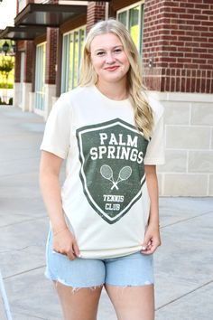 Palm Springs tennis club short sleeve graphic tee in natural and green Sizes S, M and L Fabric: `100% cotton Cotton Short Sleeve T-shirt For Tennis, Spring Sports T-shirt With Graphic Print, Green Logo Print T-shirt For Spring, Sporty Screen Print T-shirt For Tennis, Collegiate Spring Graphic Print Tops, Spring Collegiate Graphic Print Tops, Spring Sports T-shirt Pre-shrunk, Summer Cotton Tennis Tops, Summer Short Sleeve Tennis Tops