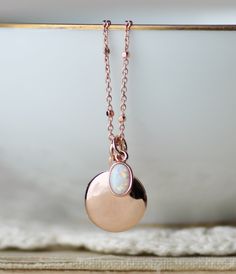 "A sweet new locket made with rose gold and an opal charm. Locket is rose gold plated and hangs from dainty rose gold plated chain. A small opal charm hangs off the side. See details and lengths below. * Locket - 13mm (1/2\") * Singapore chain -Adjusts to 18\" and 20\" only (has small ring to connect clasp at 18\" and 20\" lengths along chain) * Satellite Chain - Adjusts from 16-18\", or 18-20\" * Opal charm - Lab created opal, 6x4mm Please choose desired chain style and length at checkout. List Rose Gold Pendant Locket Necklace With Adjustable Chain, Dainty Rose Gold Pendant Locket Necklace, Rose Gold Oval Pendant Necklace With Charms, Rose Gold Locket Necklace With Round Pendant, Rose Gold Oval Charms Necklace, Oval Rose Gold Necklaces With Charms, Rose Gold Oval Necklaces With Charms, Rose Gold Charm Necklaces With Round Pendant, Rose Gold Charms Necklace Keepsake