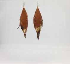 A beautiful fun pair of earrings, these are made using the finest quality soft natural tan leather with gold leaf tips. They are so light and soft, you will barely know that you are even wearing earrings. The color is the perfect accent to any outfit and is incredibly versatile. The gold simply pops from the brown background that gives a stunning iridescence when they swivel! They measure approximately 4 inches in length. The earring hooks are gold plated. If you would like a different size, ple Leather Feather Earrings, Brown Background, Natural Tan, Soft Natural, Earring Hooks, Etsy Earrings Dangle, Feather Earrings, Earrings Photo, Leather Earrings