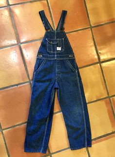 "Here is a great pair of vintage child size overalls in great condition. There are a dark cone denim with white stitching and have the \"SR Strong Reliable\" brass buttons and also label that reads \"Shrunk under the Sanforized Process Reg US Pat\". Found in an estate with flannel shirt pictured....for sale separately. Measurements taken lying flat across: Waist 12.5\", Hips 16.5\", Inseam 21.5\", Waist to hem 30\"" Vintage Denim Blue Overalls, Vintage Dark Wash Overalls, Vintage Dark Wash Bib Front Overalls, Vintage Denim Blue Bib Front Jeans, Brass Buttons, Cocktail Party Dress, Denim Overalls, Novelty Print, Lovely Dresses