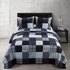 a black and white quilted comforter set with matching pillow shampoos on the bed