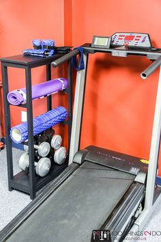 there is a treadmill and exercise equipment in the room with an orange wall behind it