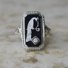 Antique Art Deco ring made of filigreed white gold. The ring is set with black onyx enameled with a peacock. There is a .10 diamond in the corner. Era: Art Deco Markings: None  Material: 14k gold (acid tested) , black onyx, diamond (approx .10ct) Ring Size: 8.5 (comes with one resizing by our jeweler)  Condition: Excellent antique condition with minor surface wear from age  Shipping is free in the United States  Follow on Instagram @LUXXORVintage Heirloom Enamel Jewelry For Formal Occasions, Formal White Gold Enamel Ring With Black Detail, Formal White Gold Ring With Black Enamel, Heirloom Enamel Jewelry With Engraving, Heirloom Engraved Enamel Jewelry, Heirloom Enamel Engraved Jewelry, Fine Jewelry Enamel With Diamond Accents, Elegant Enamel Diamond Ring, Art Deco Enamel Rings For Formal Occasions