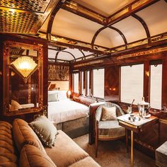 the interior of a train car with couches, tables and lamps on it's windows