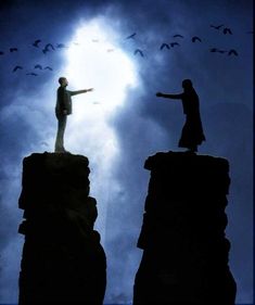 a man standing on top of a cliff with his arms outstretched to the sky and birds flying overhead