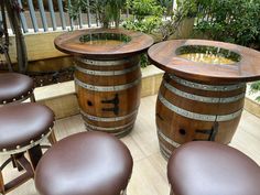 three wooden barrels sitting on top of a floor next to brown stools and tables