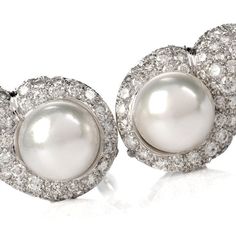 These elegant 1980's diamond and pearl tear drop shaped clip on earrings are crafted in solid 18 karat white gold, weighing 23.6 grams and measuring 30mm x 20mm. Showcasing a pair of prominent lustrous cultured pearls in white creamy color and measuring 13mm in diameter, one with very few natural inclusions. Surrounded by a tear drop shape frame pave-set with 130 round cut diamonds, collectively weighing approximately, 7.50 carats, graded G-H color, and VS1-VS2 clarity. Feature a filigree design Luxury Pear-shaped Diamond Earrings For Evening, White Gold Clip-on Diamond Earrings For Formal Events, Formal White Gold Clip-on Diamond Earrings, Luxury Pear-shaped Diamond Evening Earrings, Classic White Gold Pearl Earrings, Classic Platinum Pearl Earrings For Formal Occasions, Pear-shaped Evening Diamond Earrings, Classic Silver Platinum Pearl Earrings, White Gold Diamond Pear Shaped Pearl Earrings