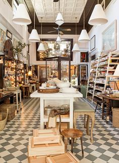 the inside of a store filled with lots of furniture and lighting hanging from the ceiling