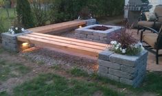 an outdoor fire pit with benches and lights