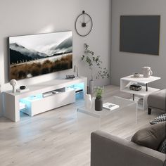 a living room with white furniture and a large flat screen tv mounted on the wall