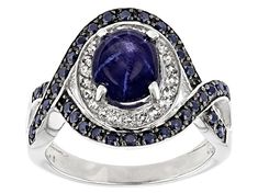 2.83ct oval cabochon blue star sapphire with .33ctw round blue sapphire and .29ctw round white topaz, rhodium over sterling silver ring. Measures approximately .83"L x .63"W. Black rhodium. Not sizeable. Silver Sapphire Ring With Diamond And Cabochon, Silver Sapphire Cabochon Ring In Fine Jewelry Style, Silver Sapphire Jewelry With Cabochon, Sapphire Jewelry With Silver Cabochon, Silver Sapphire Ring Oval Cabochon Fine Jewelry, Silver Oval Cabochon Sapphire Ring Fine Jewelry, Silver Sapphire Ring, Oval Cabochon, Fine Jewelry, Silver Sapphire Oval Cabochon Ring, Silver Sapphire Ring With Oval Cabochon