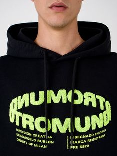 a man wearing a black hoodie with neon writing on it