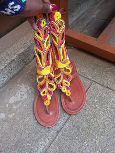 Comftable and stylish gladiator Masai sandals which are made of beads and Leather material are easy to wear at any given time. They can go with any fashion. They are made from environmental friendly materials. They can be adjusted to your liking in size. Purchase this beautiful pair and get a pair of earrings for free Beaded Toe Post Sandals For Vacation, Beaded Toe Post Sandals For Beach, Beaded Barefoot Sandals For Vacation And Festivals, Handmade Orange Sandals For The Beach, Handmade Orange Sandals For Beach, Orange Bohemian Sandals For Vacation, Summer Adjustable Beaded T-strap Sandals, Beaded T-strap Sandals With Open Toe For Summer, Summer Beaded T-strap Sandals With Open Toe