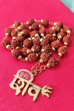 Rudraksha mala 55 beads gold plated caps with shiv trishul pendent. A Rudraksha mala, made from the seeds of the Rudraksha tree, holds deep spiritual and healing significance. It is believed to provide peace of mind, enhance concentration, reduce stress, and balance energies. Used in meditation and prayer, the mala is thought to help the wearer connect with higher consciousness and promote inner harmony. Each bead is considered sacred, and the number of beads (usually 55) has special spiritual s Trishul Locket, Shiv Trishul, Rudraksh Mala, Rudraksha Jewelry, Rudraksha Mala, Inner Harmony, Om Namah Shivaya, Higher Consciousness, Prayer Beads