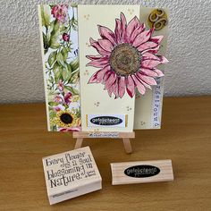 a card and stamp set sitting on a wooden table next to each other with flowers