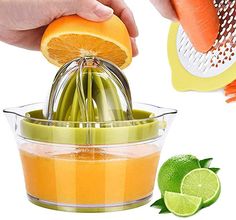 a person is squeezing orange juice into a fruit and vegetable processor