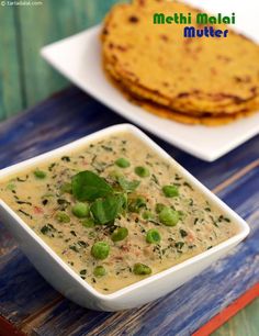 there is a bowl of soup next to some pita bread