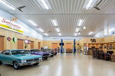 there are many old cars parked in the garage with wood paneling on the walls