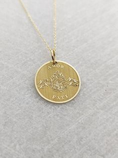 "Amor Fati Necklace - Engraved Love of Fate Charm - Gold Graduation Charm - Gold Stoic Pendant ▪️ A beautiful and clean engraved Amor Fati pendant made out of 14K Solid Real Gold. Available only in yellow gold! Pendant Thickness: 0.50mm Jump Ring inner diameter: 4mm Dimensions: - 13mm / 0.52 inches - 15mm / 0.59 inches - 18mm / 0.70 inches - 20mm / 0.78 inches - 22mm / 0.86 inches - 24mm / 0.94 inches Necklace Length - You can choose your chain length from 35CM to 50CM. The pendant is available Spiritual 14k Gold Jewelry Stamped 14k, Symbolic Yellow Gold Jewelry For Valentine's Day, Symbolic Gold Jewelry For Valentine's Day, Spiritual 14k Gold Jewelry For Anniversary, Engraved 14k Gold-filled Pendant Jewelry, Engraved Pendant In 14k Gold Filled Jewelry, Engraved 14k Gold Filled Pendant Jewelry, Engraved 14k Gold-filled Yellow Gold Jewelry, 14k Yellow Gold Necklace For Promise