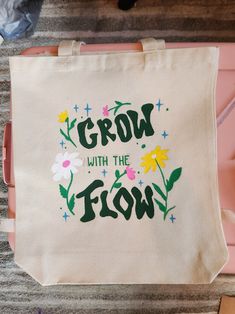 a tote bag that says grow with the flow