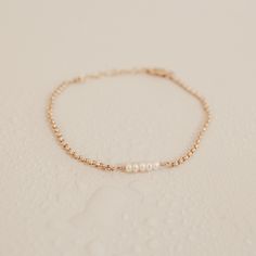 Subtle and oh-so-sweet, our Ariel Tiny Pearl Bracelet is one of those easy-to-wear pieces that adds a touch of elegance to any look. An effortless beauty, you'll never want to to be without these dainty pearls. Crafted with love in our sunny Brisbane studio, each KBN piece is made and assembled by our small team. As we create our jewellery by hand, there will always be variation in each piece. The beauty of this process is that each KBN piece is unique to its wearer. Delicate 14k Gold Filled Jubilee Bracelet, Feminine Gold Bracelet Jewelry, Dainty 14k Gold Bracelet With Pearl Chain, Dainty Rose Gold Bracelet With Pearl Charm, Feminine Hypoallergenic Gold Jewelry, Hypoallergenic Feminine Gold Jewelry, Rose Gold Dainty Bracelets With Pearl Chain, Dainty Gold Pearl Charm Bracelet, Dainty Rose Gold Bracelets With Pearl Chain