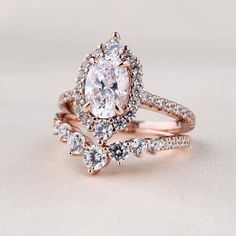 an engagement ring set with a pear shaped diamond and two rows of diamonds on each band