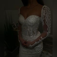 a woman in a wedding dress is posing for the camera with her hands on her hips