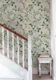 a staircase with wallpaper and white railings