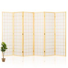 a room divider with a potted plant next to it on a white surface