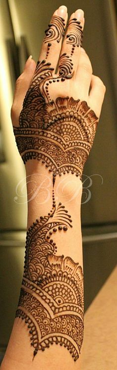 a woman's hand with henna tattoos on it