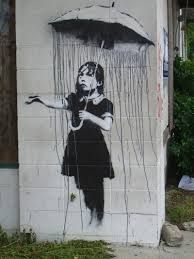 a woman with an umbrella painted on the side of a building