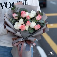 a woman holding a bouquet of roses in her hands