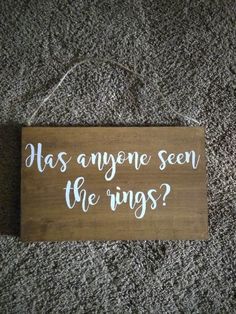 a wooden sign that says, has anyone seen the rings? on carpeted floor