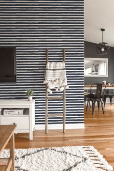 a living room with blue and white striped wallpaper, wood flooring and furniture