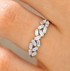 a woman's hand with a diamond ring on top of her finger and the band is made out of white gold