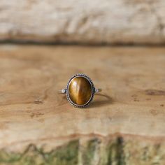 Sometimes you want to gaze down at your ring and see perfect balance and grace. That's what the Dainty Yellow Tigers Eye Delica Ring has to offer. High grade Yellow Tigers Eye with a simple, sterling silver design. Perfect little ring. Lovely, traditional, dainty ring of 10X12mm Yellow Tigers Eye cabochon set in .925 sterling silver oxidized and burnished bezel and wire. Simple, elegant and perfect. This lovely little ring is created using traditional silversmithing techniques in my Baltimore, M Sterling Silver Spiritual Rings With Polished Finish, Spiritual Sterling Silver Rings With Polished Finish, Sterling Silver Rings With Polished Finish In Spiritual Style, Oval Spiritual Rings With Polished Finish, Oval Spiritual Ring With Polished Finish, Spiritual Oval Sterling Silver Rings, Adjustable Oval Rings In Brown, Adjustable Oval Brown Rings, Nickel-free Oval Sterling Silver Crystal Ring