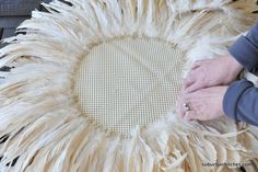 a woman is working on a piece of furniture made out of ostrich feathers