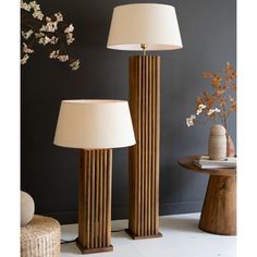 two lamps sitting next to each other on top of a white carpeted floor in front of a gray wall