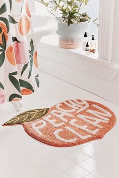 a bath room with a toilet and a flowered shower curtain next to a window