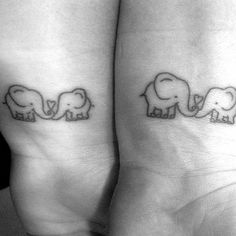 two small elephants are on the back of each other's legs, both with their trunks