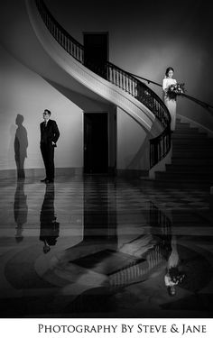 a man and woman standing in front of a staircase